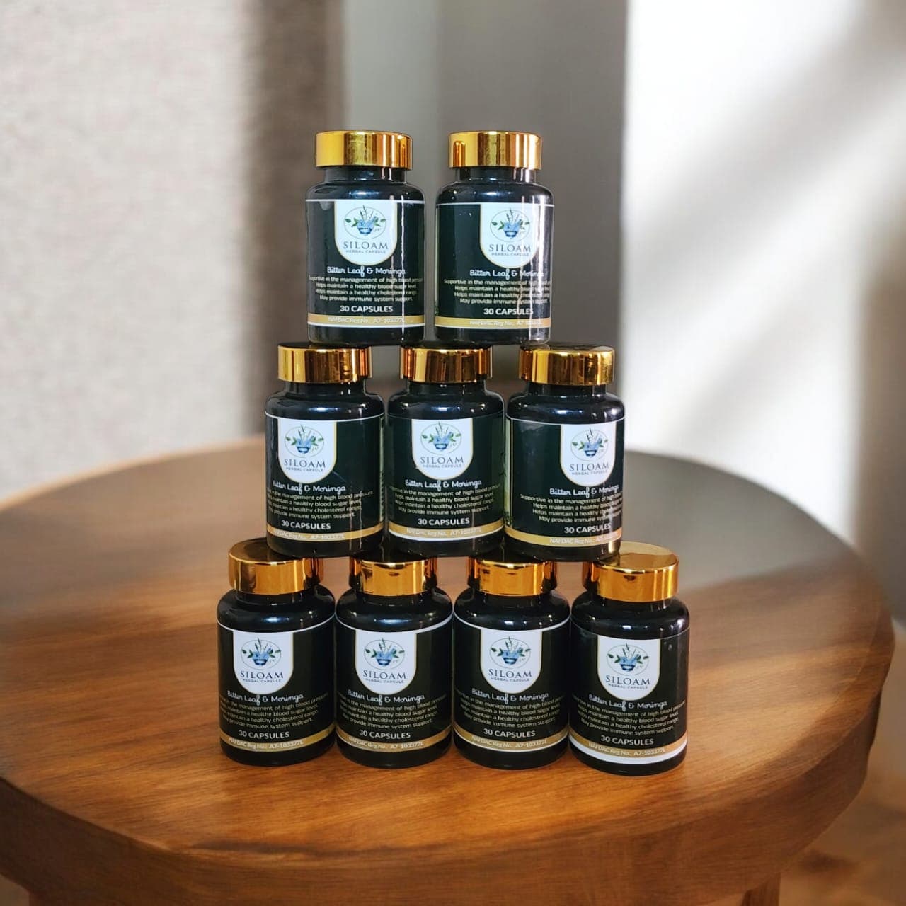Stack of Siloam Herbal Capsule bottles on a wooden table